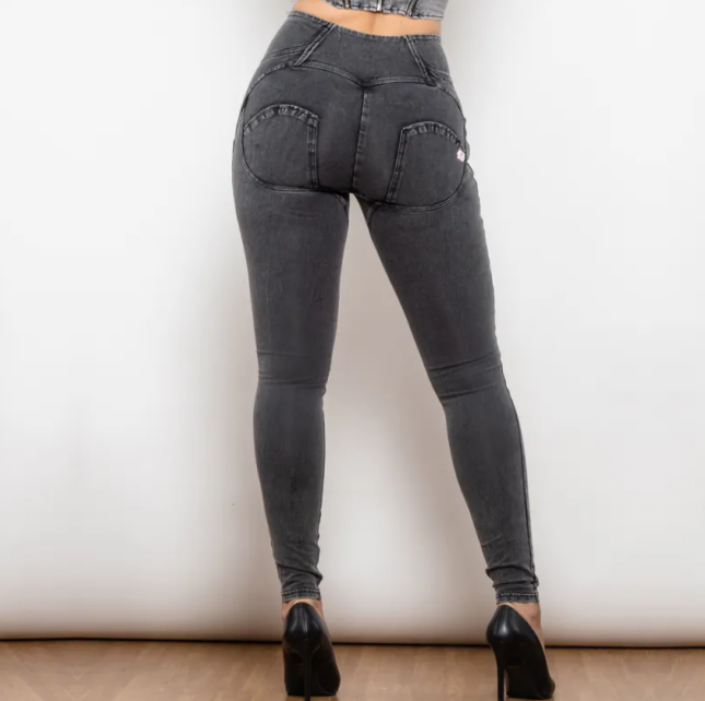 Person wearing black high-waisted jeans on a plain background