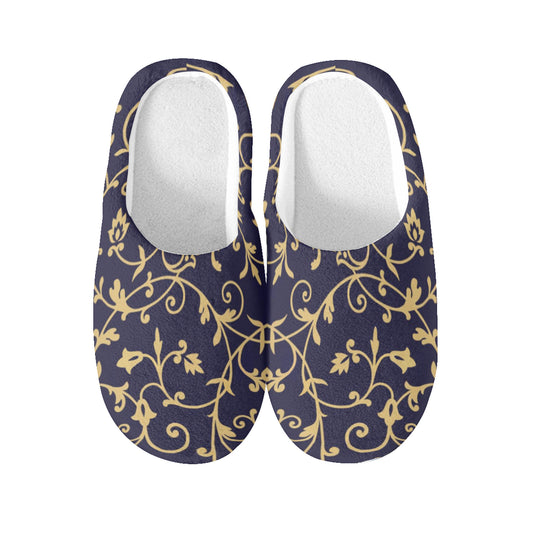Pair of black slippers with gold floral pattern on a white background