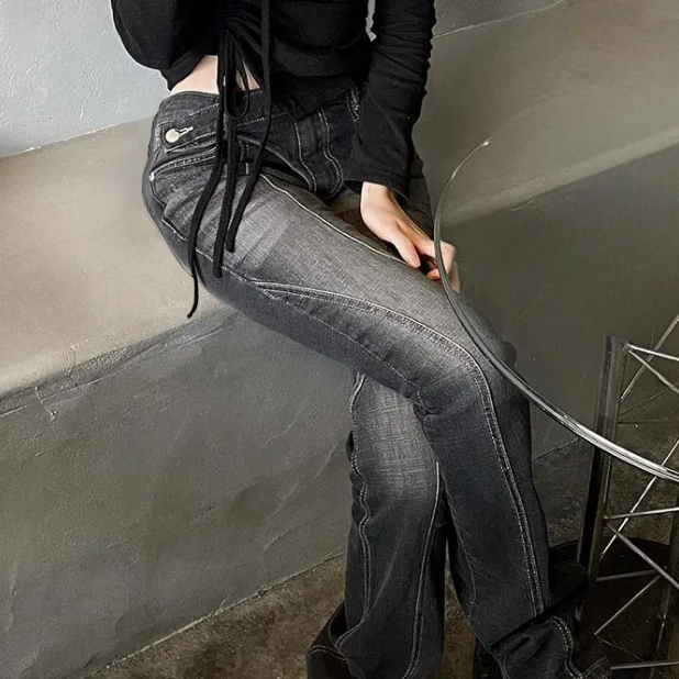 A woman wearing black jeans and black shirt sitting on a bench by a glass table