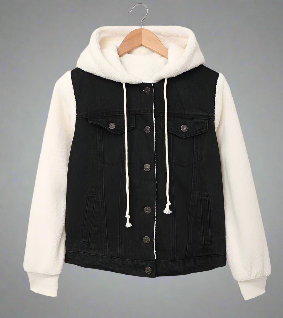 Black denim jacket with white hoodie on a hanger against a beige background