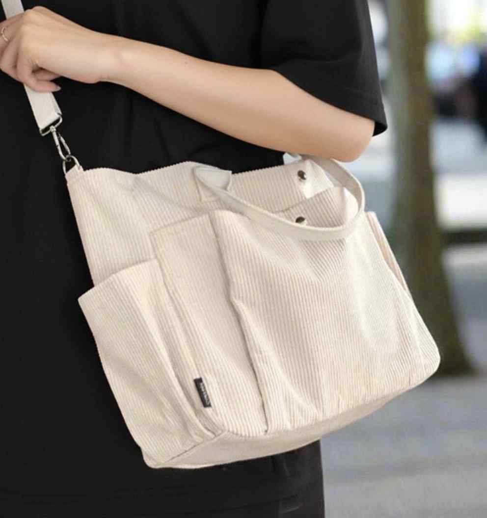 Person holding a beige corduroy bag with a blurred background