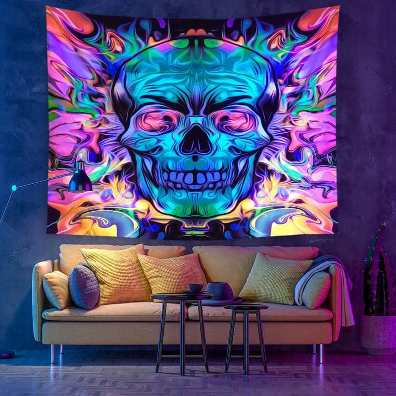 Colorful tapestry with abstract design of a skull on a wall above a couch.