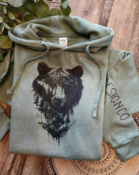 Green hoodie with bear graphic on a wooden surface