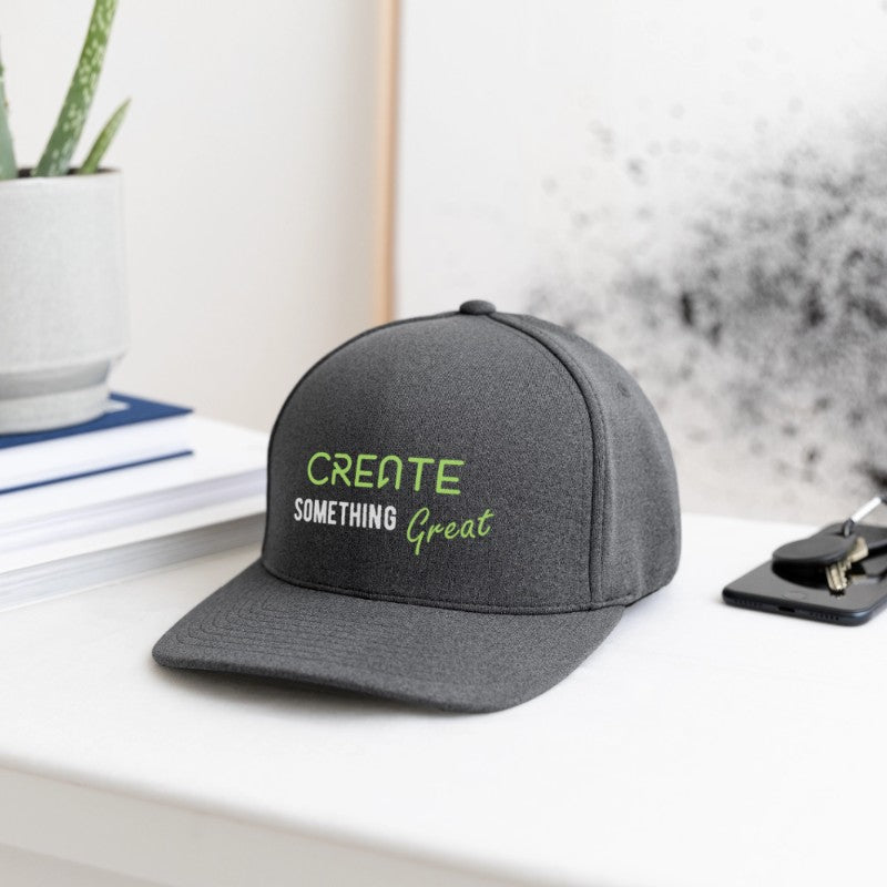 Gray cap with 'Create Something Great' text on a desk with office items.