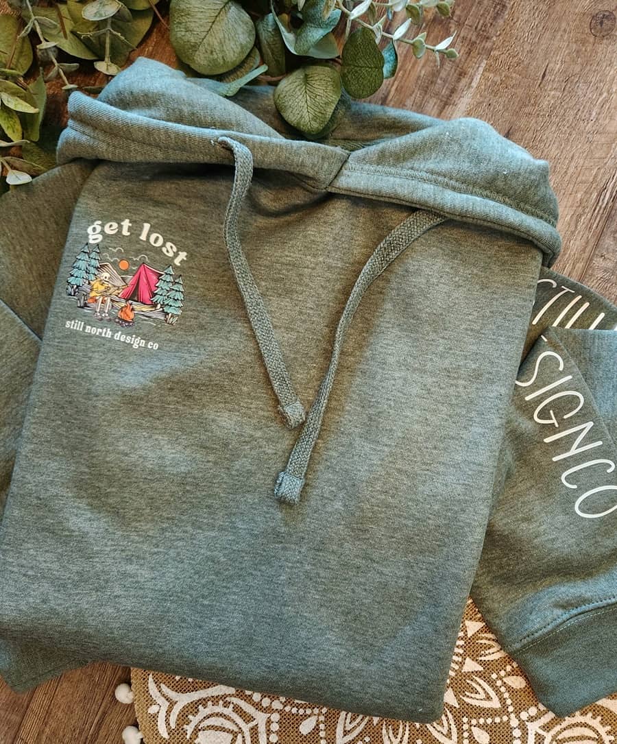Gray hoodie with a printed design on a wooden surface