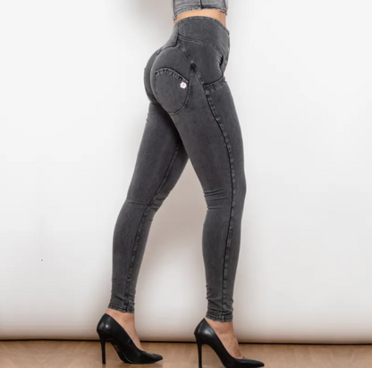 Person wearing black high-waisted jeans and black high heels on a plain background