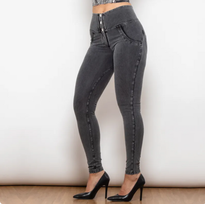 Person wearing gray high-waisted jeans with a plain background