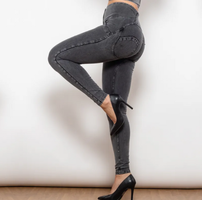 Person wearing black high-waisted jeans and black high-heeled shoes on a white background