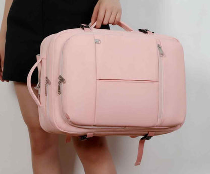 Pink suitcase held by a person against a plain background