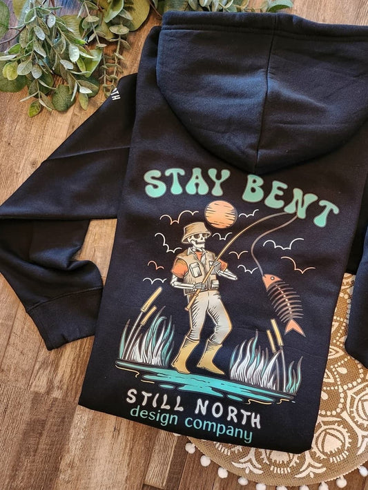 Black hoodie with 'Stay Bent' graphic design on a wooden surface