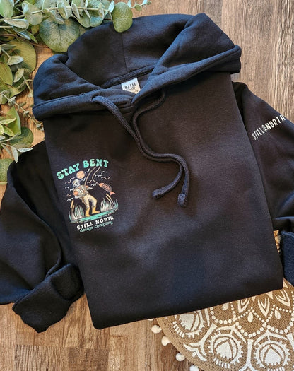 Black hoodie with a graphic design on a wooden surface
