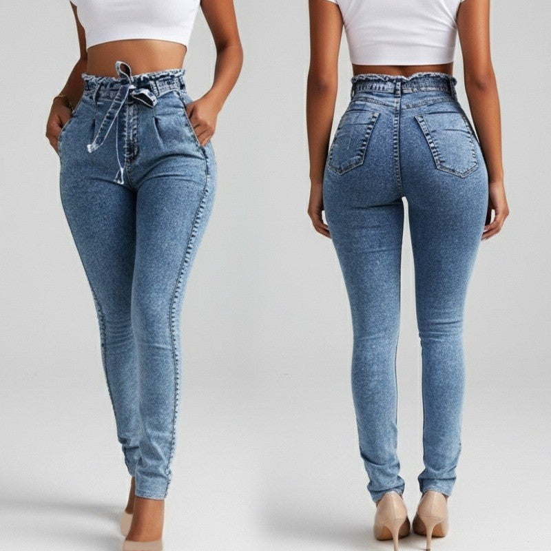 Blue jeans worn by a person on a plain background