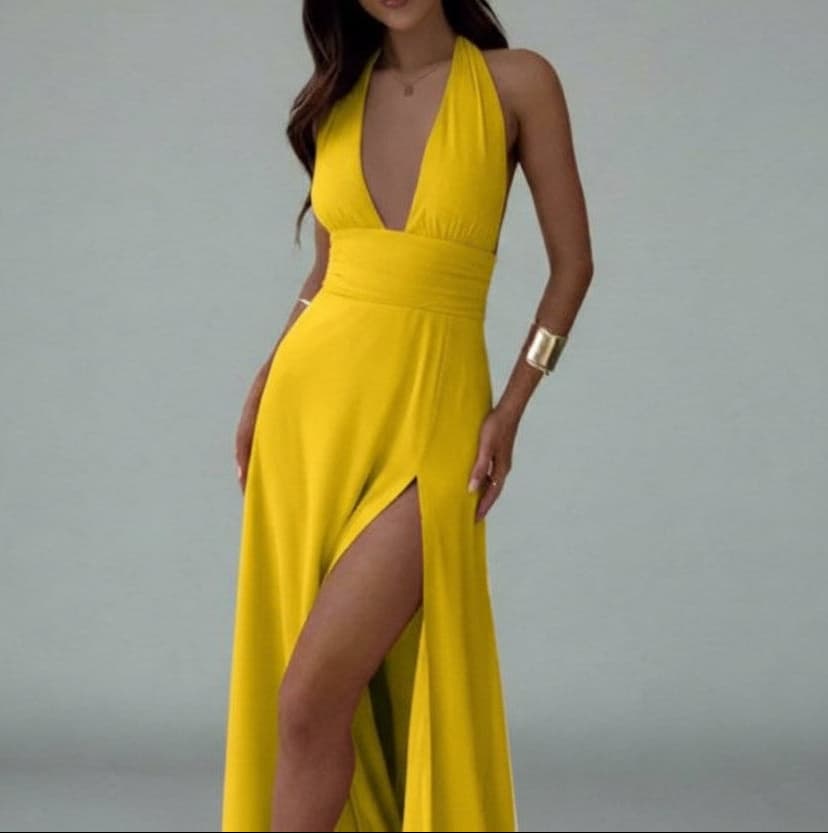 Yellow evening gown with a deep neckline and slit on a gray background