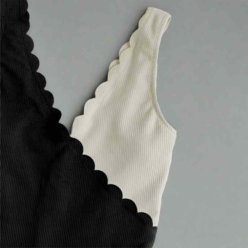 Black and beige ribbed swimsuit on a gray background