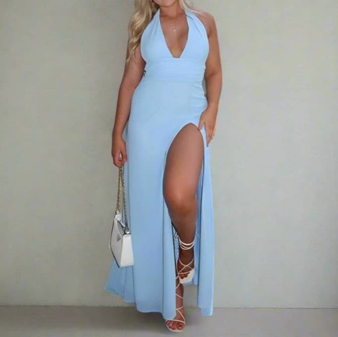 Woman wearing a light blue halter neck dress with a high slit on a plain background