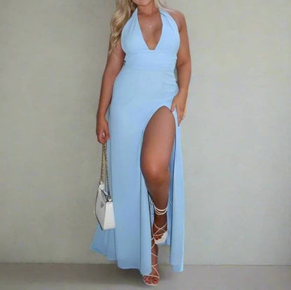 Woman wearing a light blue halter neck dress with a high slit on a plain background